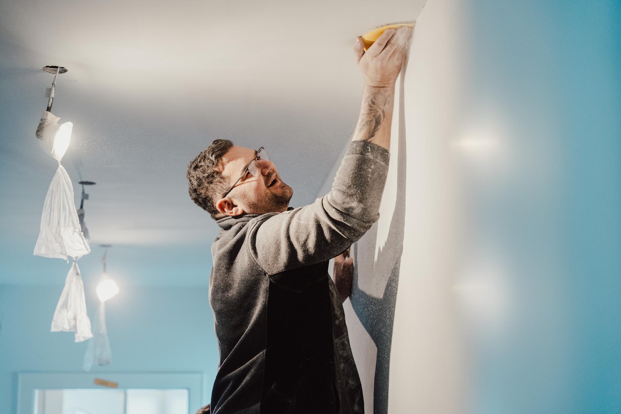 Ein Mann, der eine Decke per Hand schleift.